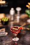 Handcrafted 1:12 scale Crimson Hour blood orange cocktail in a stemmed coupe with a black-and-gold rim, miniature blood orange slice, and rosemary garnish.