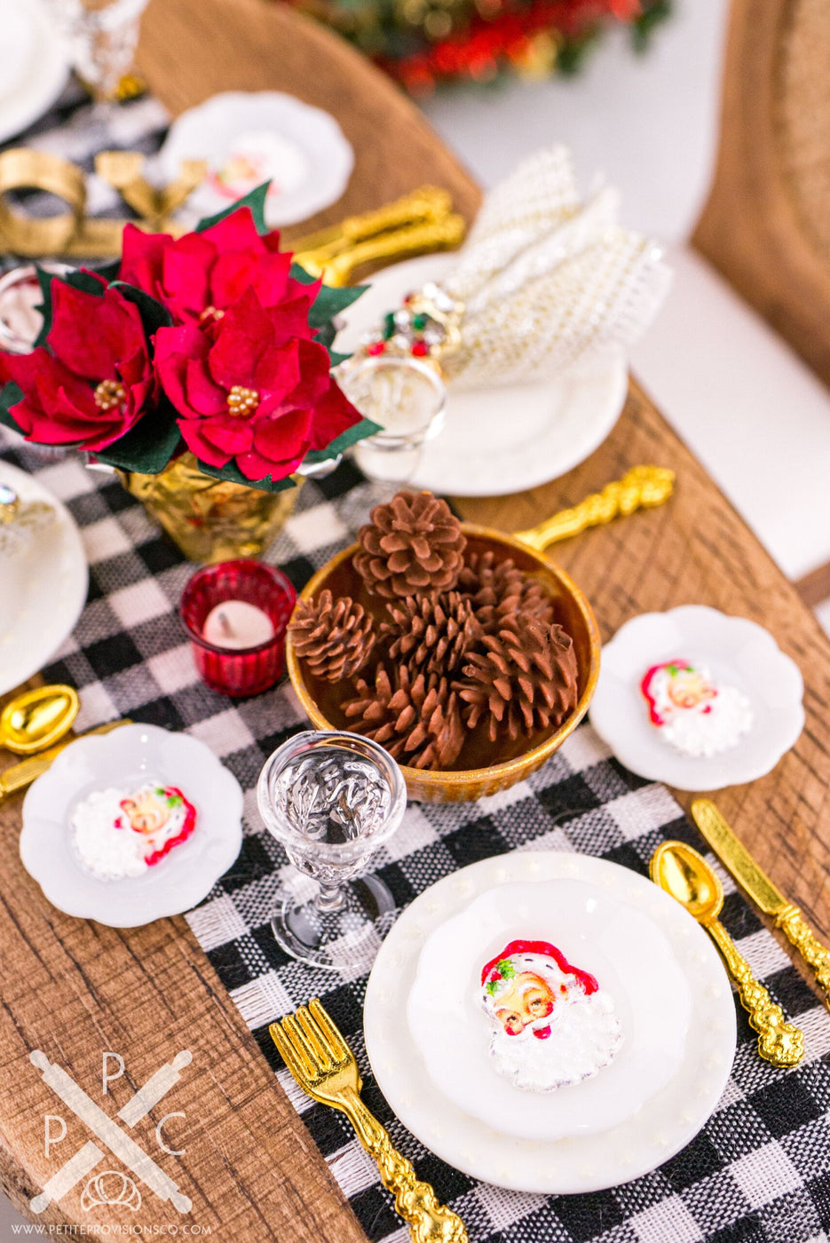 Miniature Christmas table setting featuring festive Santa Claus plates.